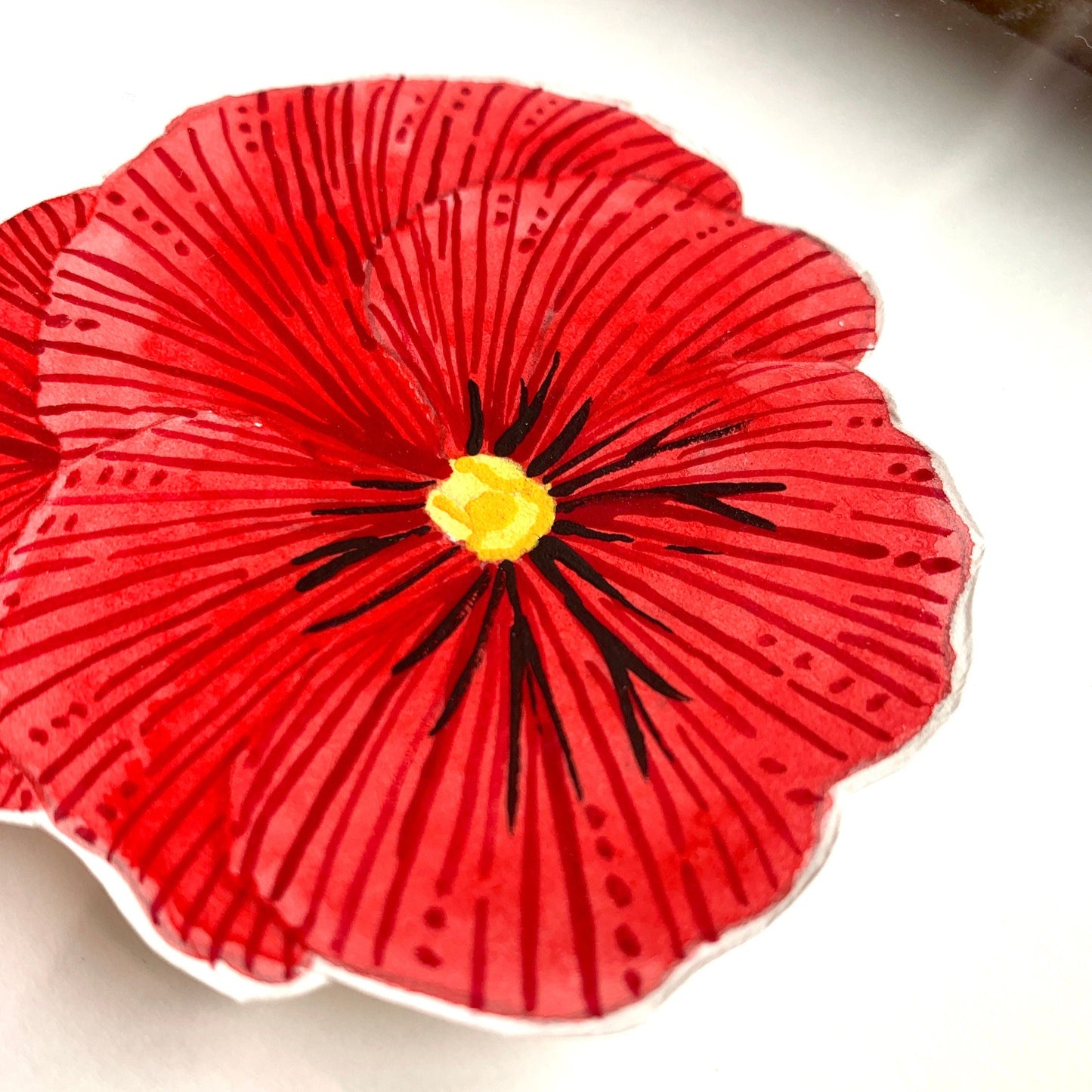 A close up of a red pansy flower painting showing the line details and paint textures.