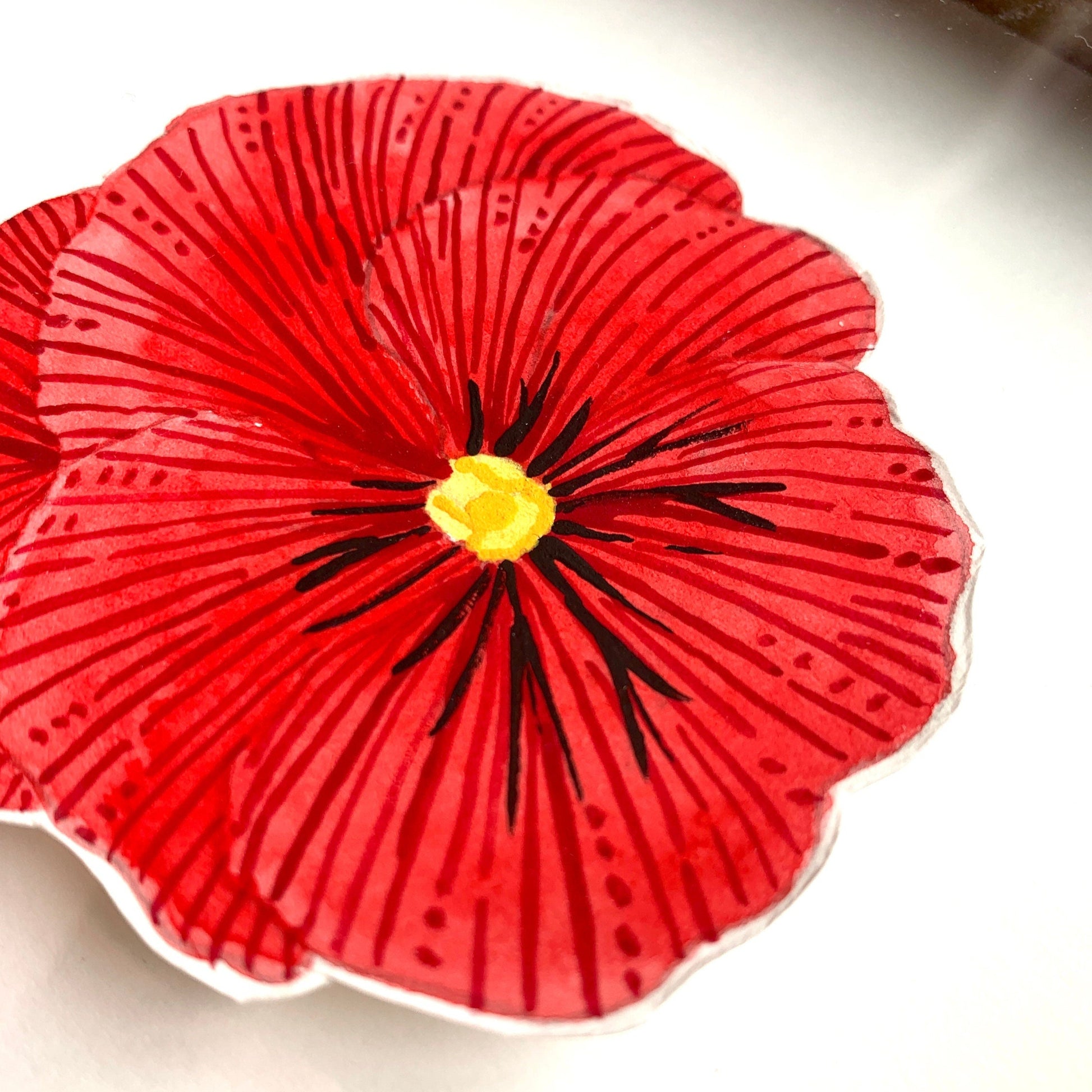 A close up of a red pansy flower painting showing the line details and paint textures.