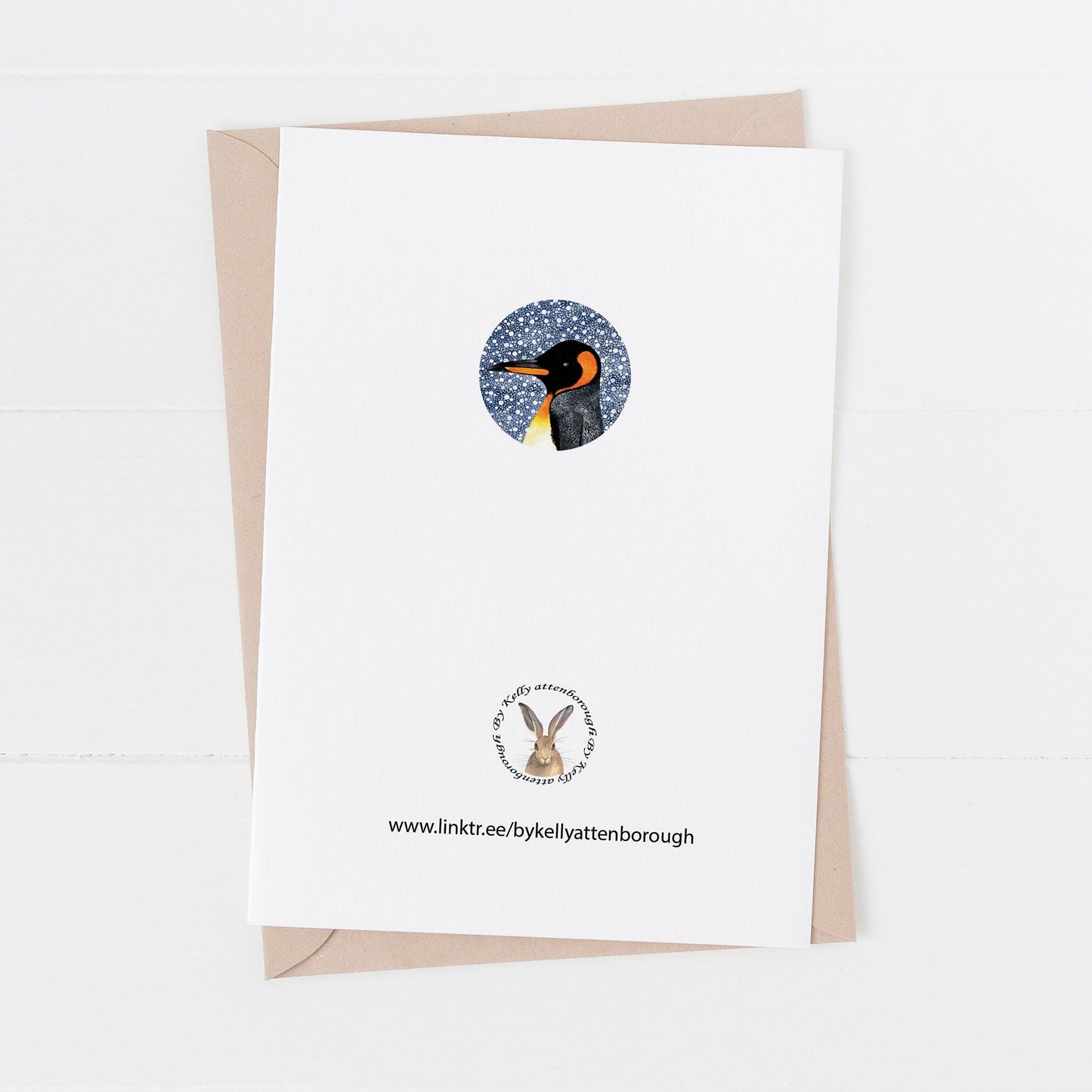 the back of a Greeting card with penguin illustration on a white background