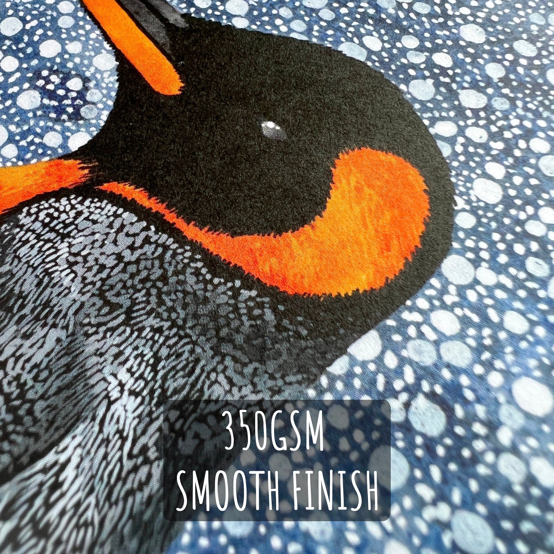 winter Penguin Christmas Card close up showing the details of the illustration and paper stock with the text 350gsm smooth finish.