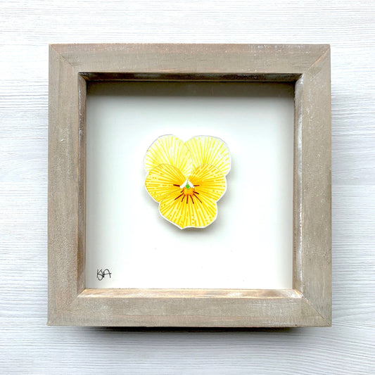 A hand-painted vibrant yellow pansy flower watercolour in a rustic washed effect box frame.